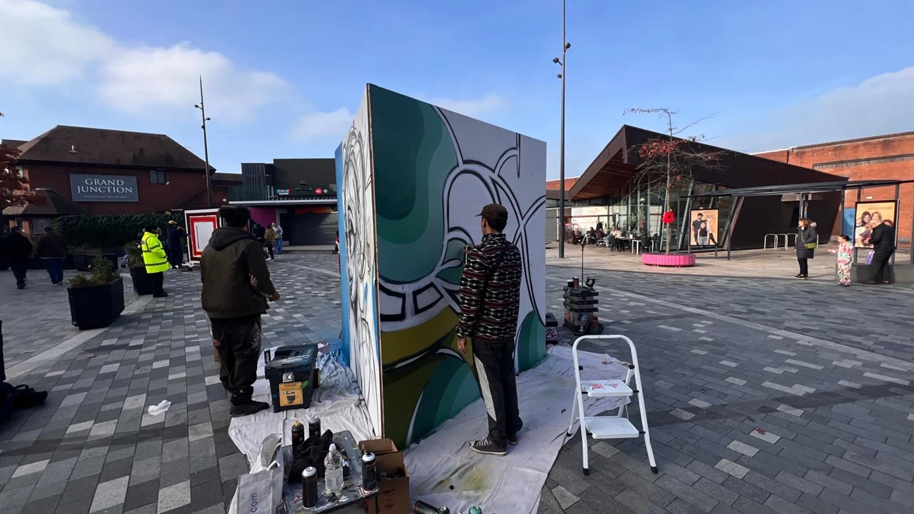 Freestanding painted panels and people in Lyceum Square beneath a clear blue sky.