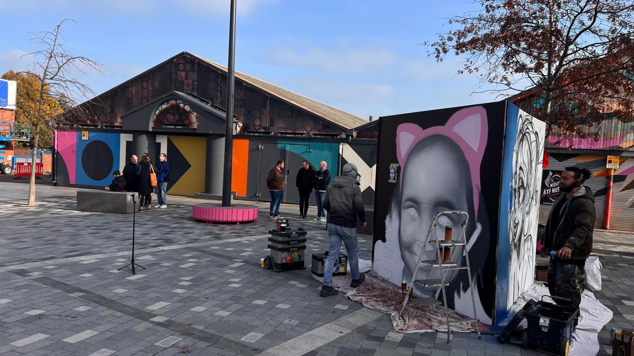 Painting supplies and freestanding panels in Lyceum Square, including a portrait with pink cat ears.