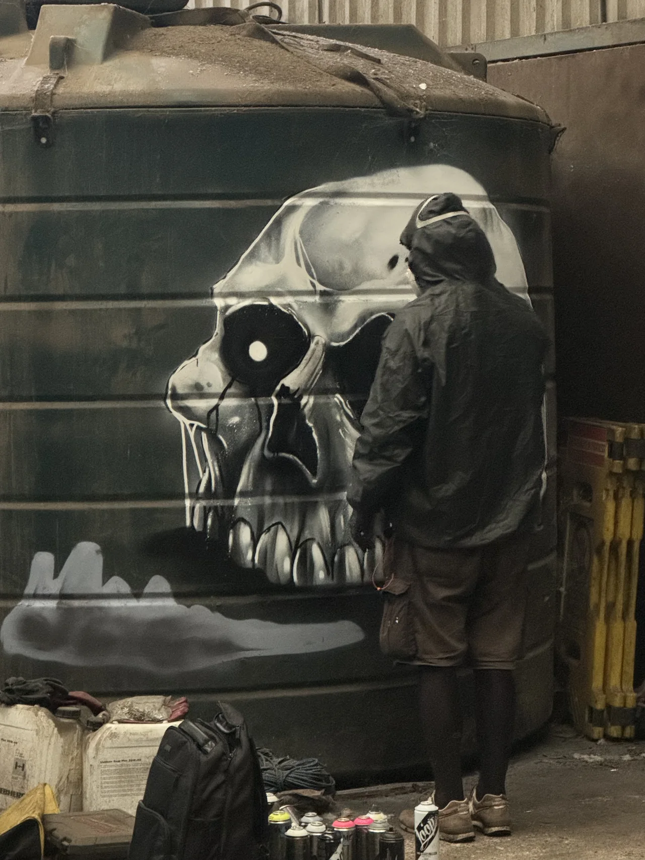 A monochrome skull painted on a dark panel inside the workshop.