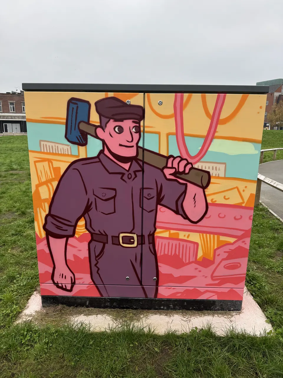 Painted utility cabinet: an illustrated engineer in maroon overalls carries a sledgehammer on his shoulder, with pink and yellow industrial shapes behind.