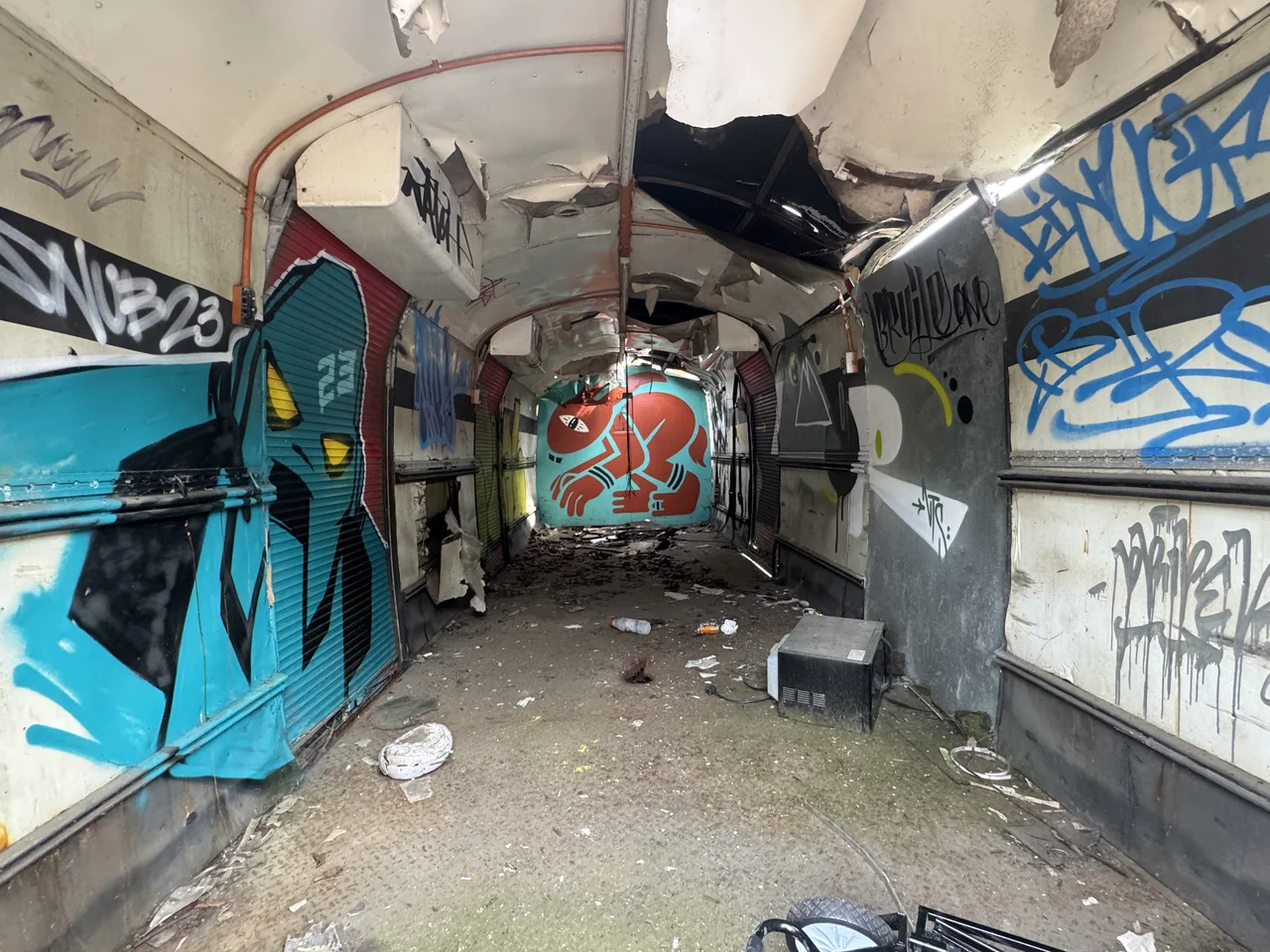 Graffiti-painted panels seen through the stripped interior of a vehicle.