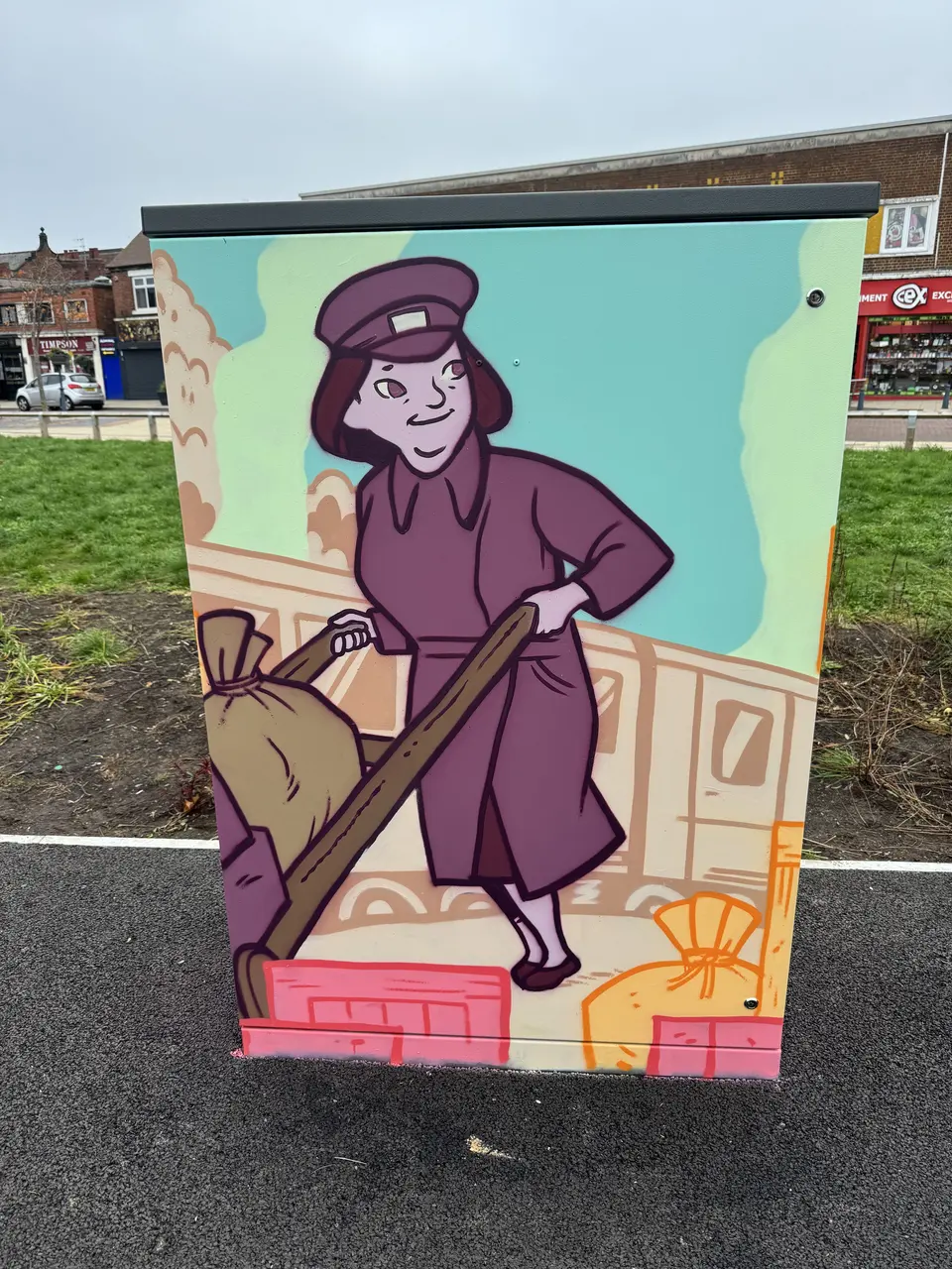 Painted utility cabinet: an illustrated woman in a maroon uniform and cap carries a sack beside a railway carriage, on a turquoise and peach ground.