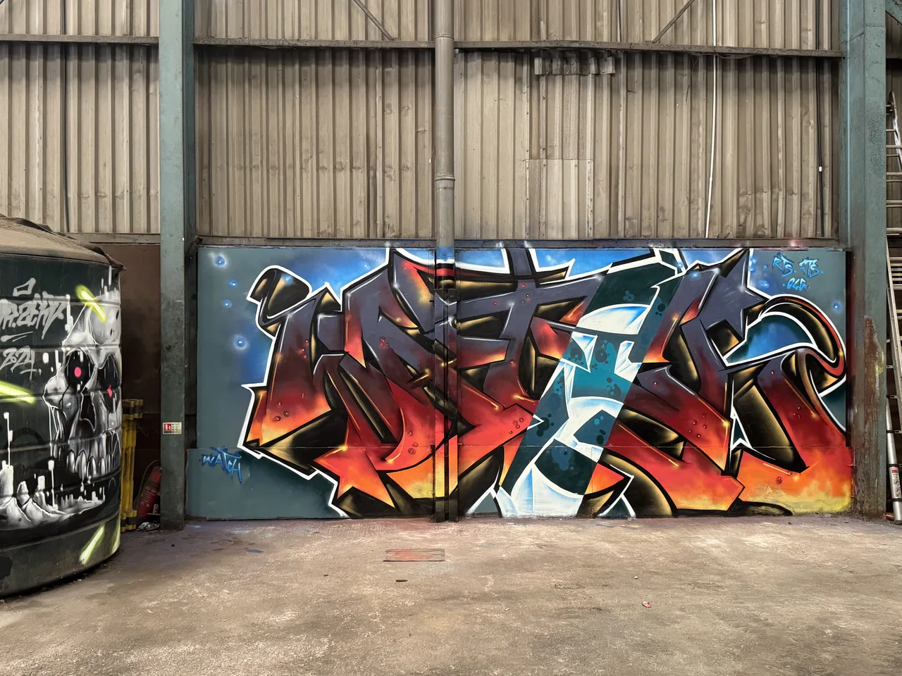 Red, black and turquoise angular graffiti on a large workshop panel.