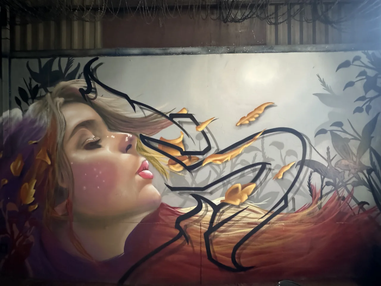 A painted portrait and delicate branch forms on a panel inside the workshop.